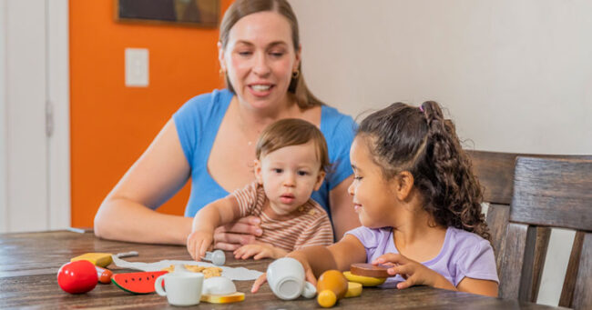 Mother feeding daughter and son at table