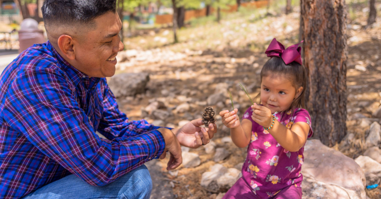 A Navajo father interacts with his daughter outside.
